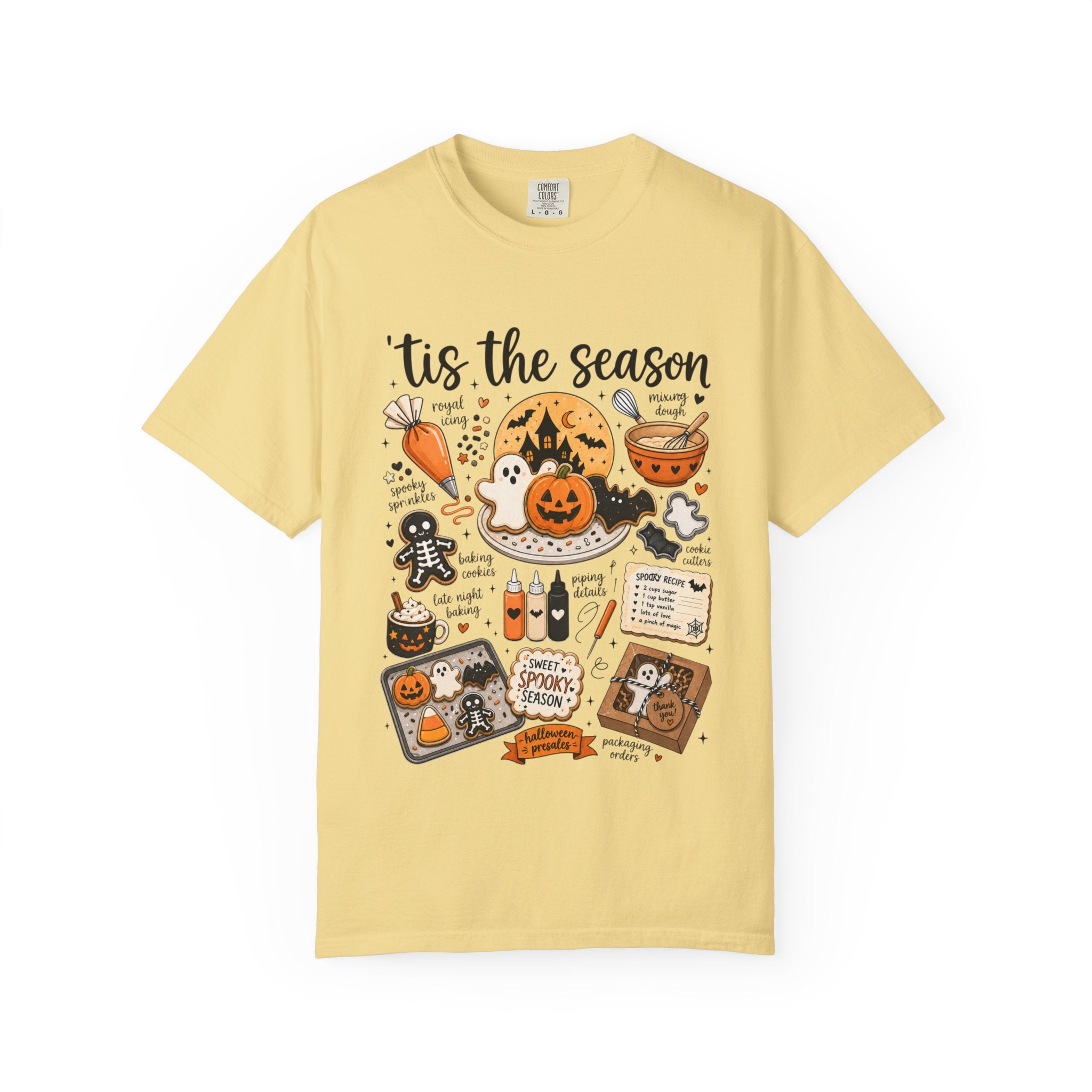 A pale yellow short-sleeve t-shirt with a detailed, colorful Halloween-themed graphic print on the front, featuring illustrations of pumpkins, ghosts, a cauldron, and spooky text.