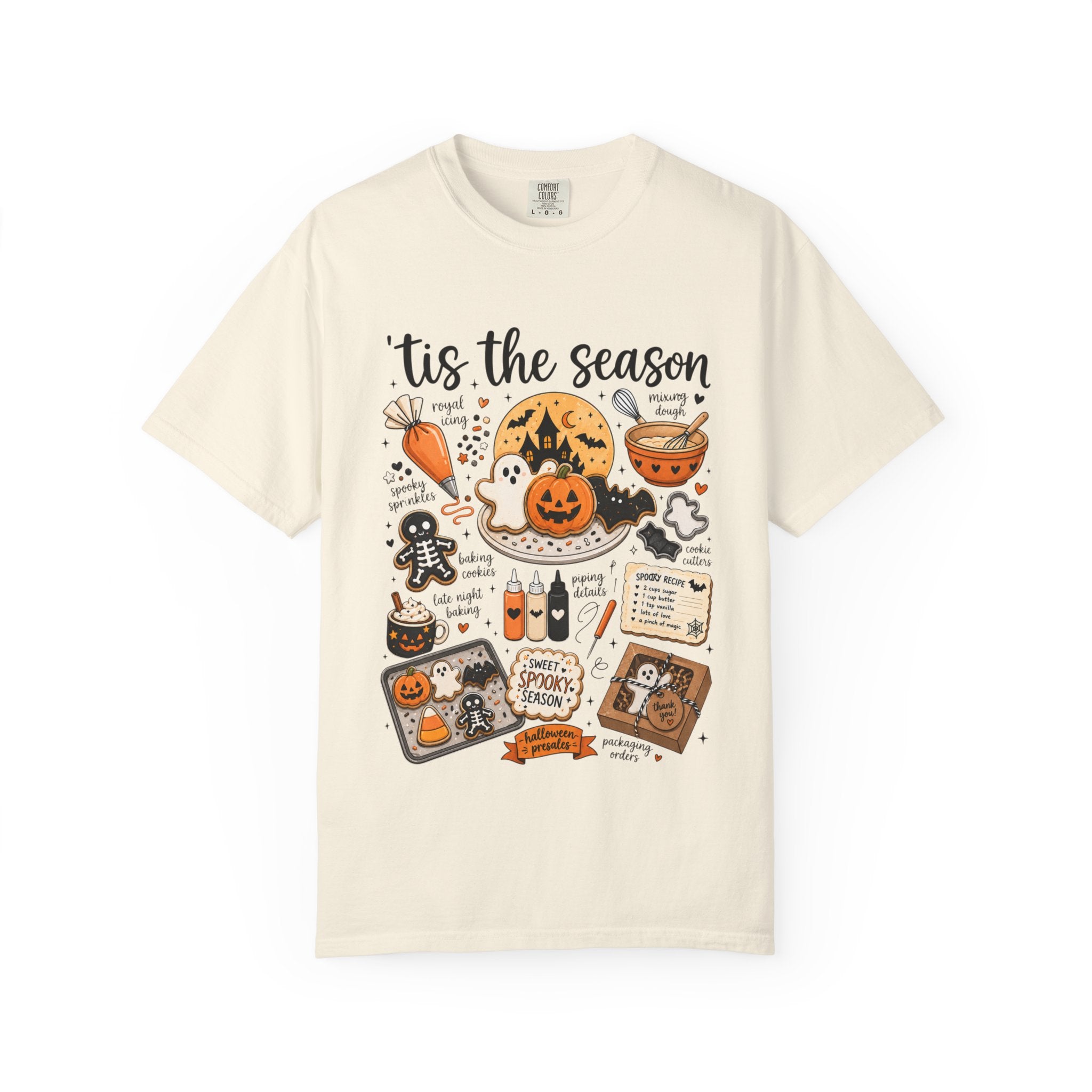 An off-white short-sleeve t-shirt with a detailed Halloween-themed graphic print on the front, featuring illustrations of pumpkins, ghosts, a cauldron, and spooky text.