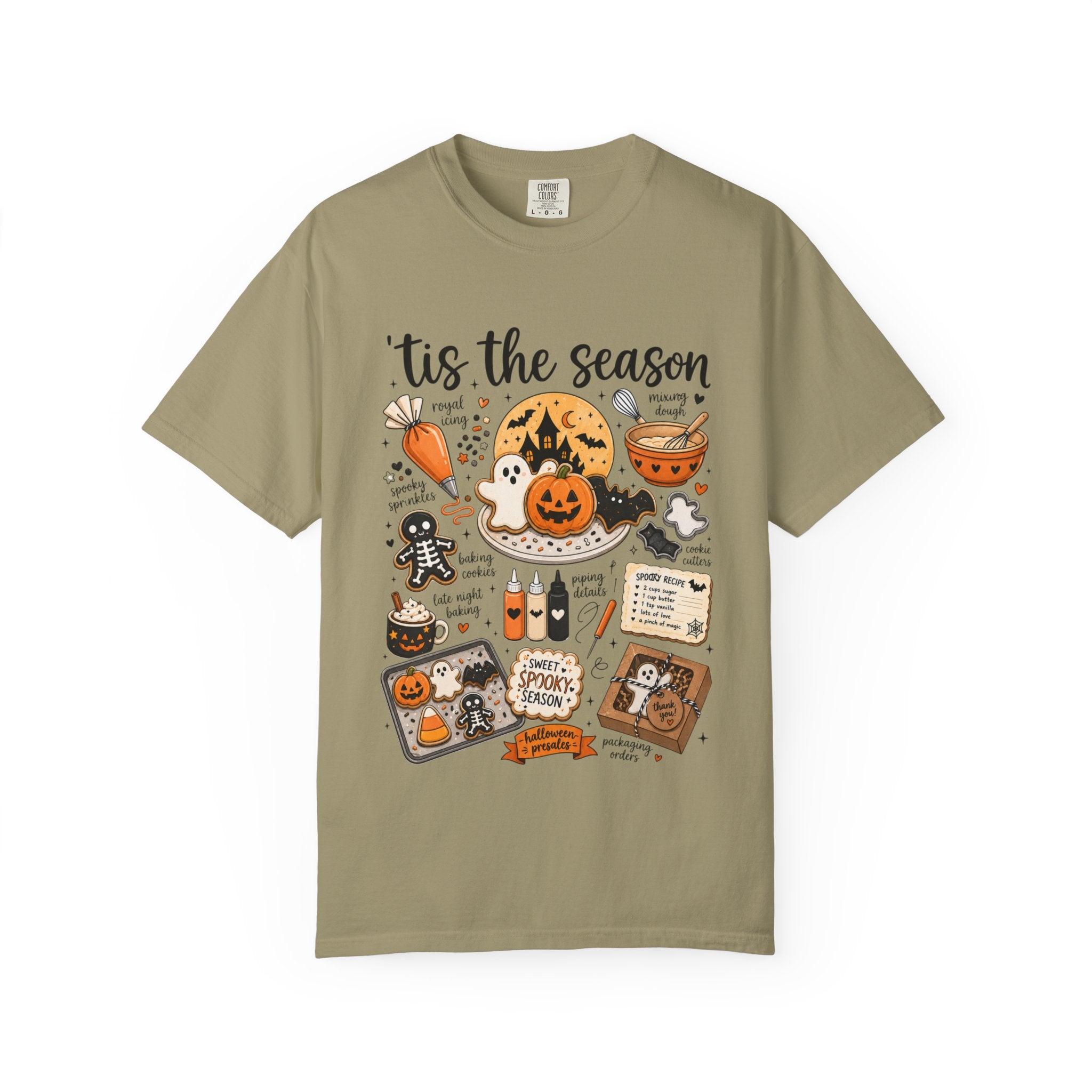 An olive green short-sleeve t-shirt with a detailed Halloween-themed graphic print on the front, featuring illustrations of pumpkins, ghosts, a cauldron, and spooky text.