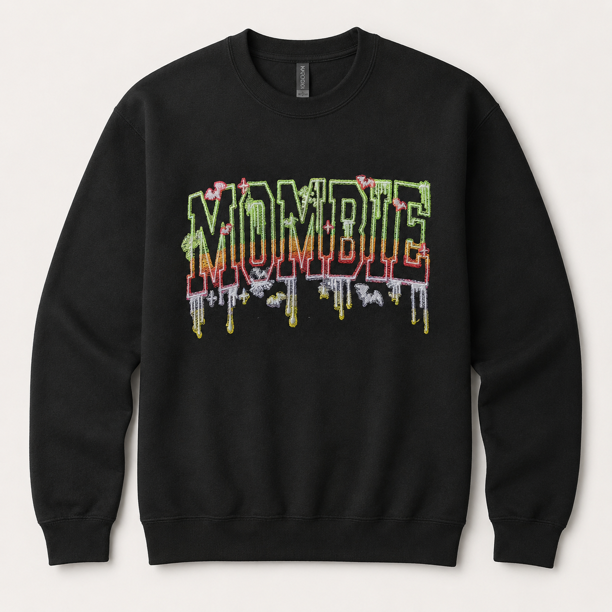 A black crewneck sweatshirt featuring a colorful 'MOMBIE' graphic on the chest in a dripping, layered style with green, red, and yellow tones, set against a light beige background.