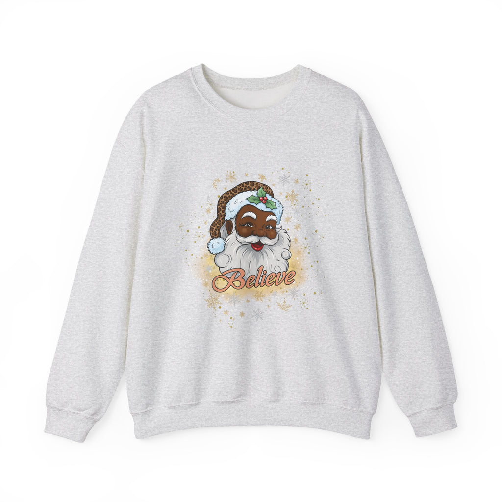 A light heather gray crewneck sweatshirt featuring a cartoon illustration of a Black man dressed as Santa Claus with a white beard, green hat, and the word 'Believe' written below in orange script.