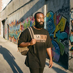 Man walking on a street with colorful graffiti in the background